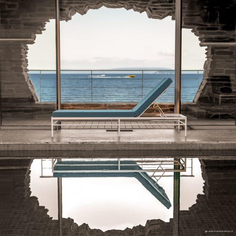 Indoor spa pool and opening in the rock overlooking the sea