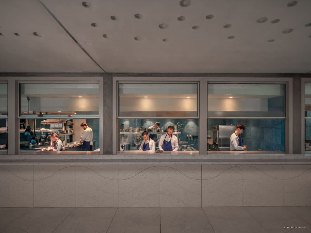 Kitchen brigade behind the glass partition at L'Oursin restaurant