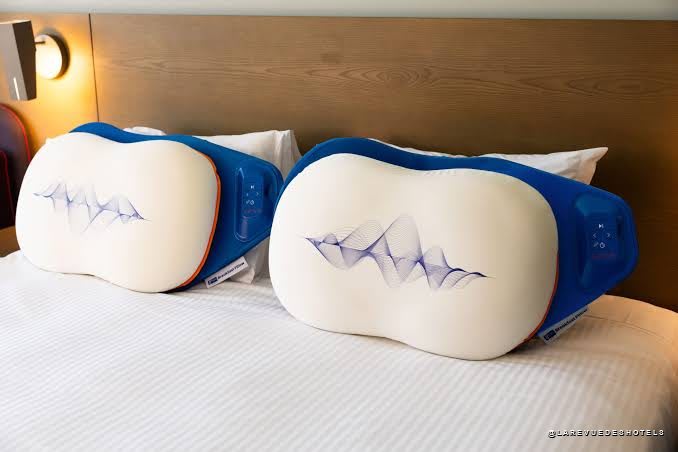 Deux Breakfast Pillow de Holiday Inn Express posés côte à côte sur un lit d'hôtel