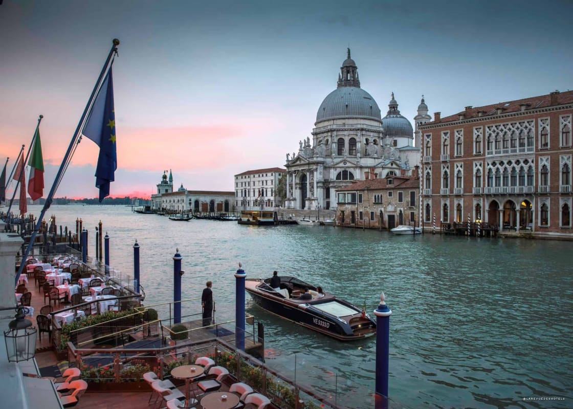 Le Gritti Palace sur le Grand Canal à Venise au coucher du soleil, terrasse dressée et bateau-taxi
