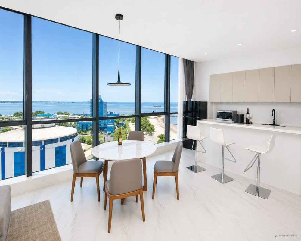 Salón de una suite del Atlantic Suites Hotel en Georgetown, con cocina abierta y ventanal al océano Atlántico