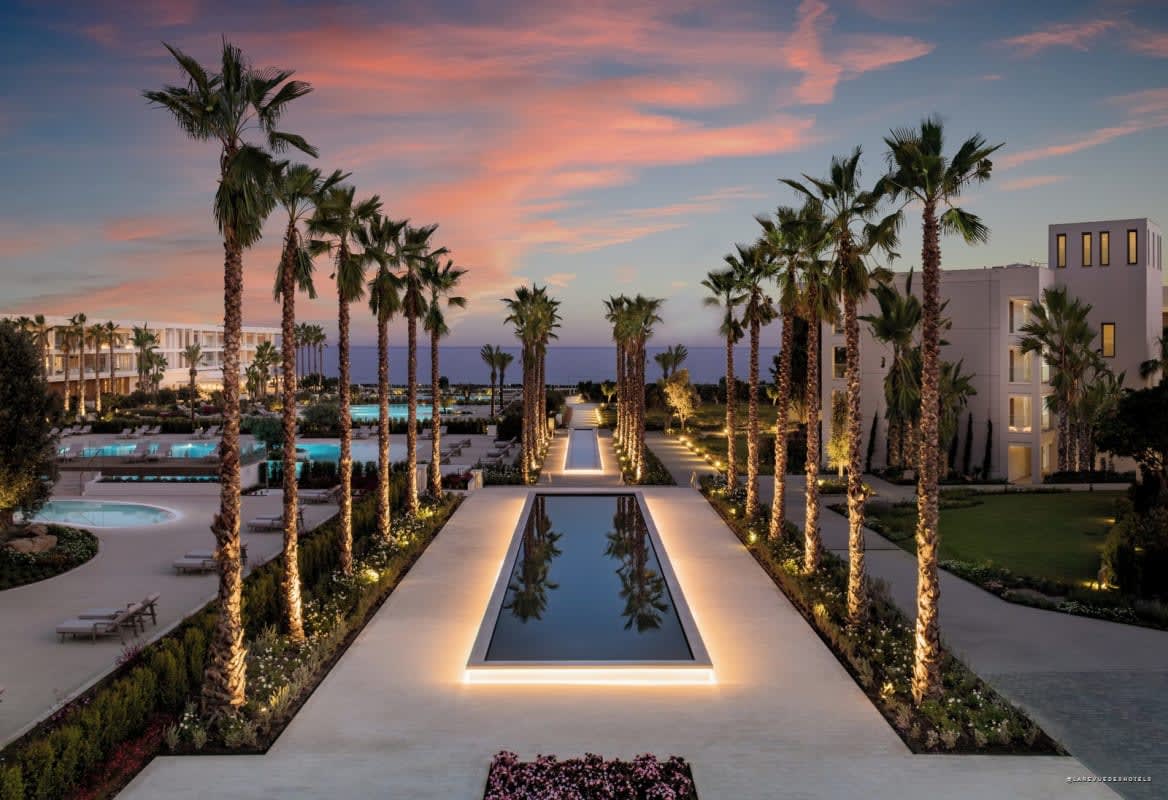 Piscine principale d'un resort Ikos en Méditerranée, bordée de palmiers