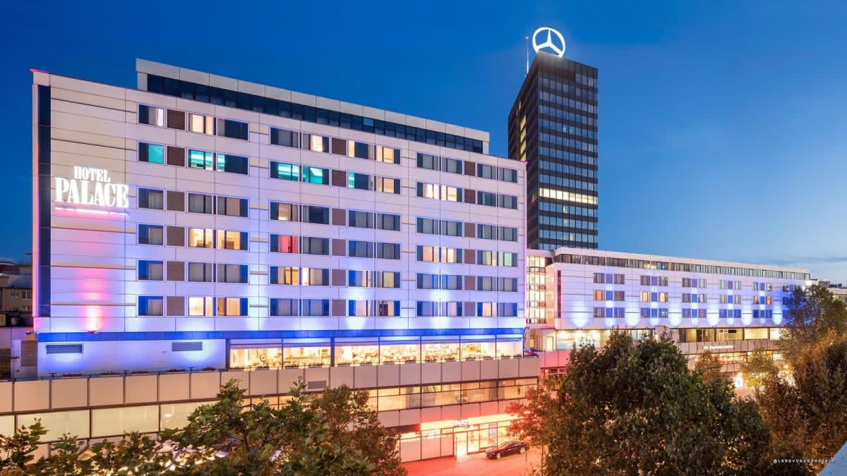 La fachada iluminada de azul del Hotel Palace Berlin al anochecer, en el barrio de la City West