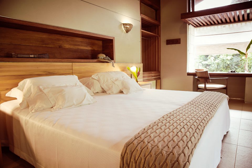 Une chambre du Cristalino Lodge, boiseries et lit double