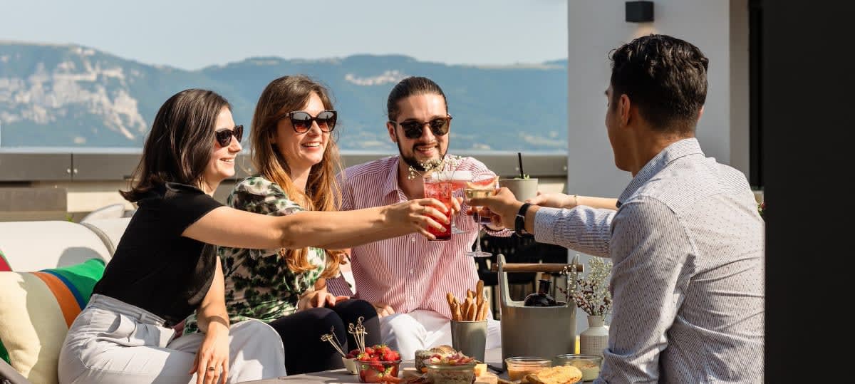 Des clients trinquent sur la terrasse de La Suite 1201, face au lac Léman et aux reliefs environnants