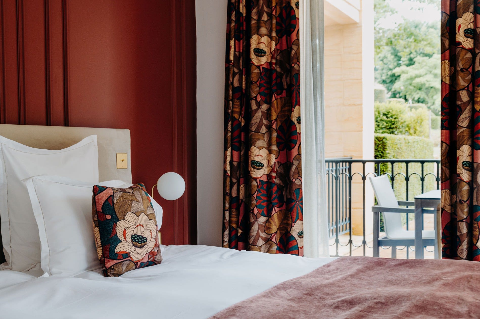 Chambre du Domaine de Rochebois, mur bordeaux et balcon sur la campagne