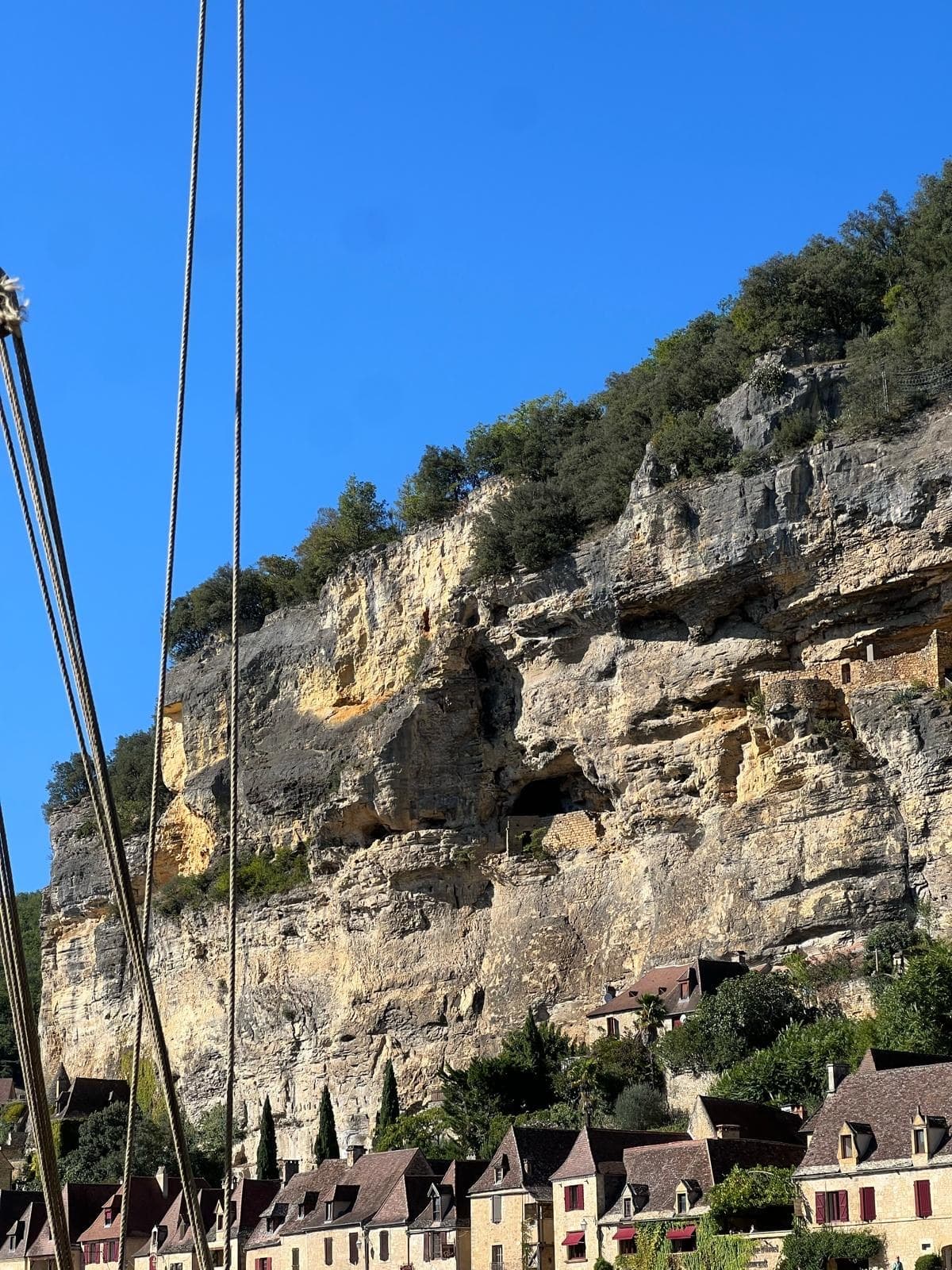 Un village blotti sous une falaise, dans la vallée de la Dordogne