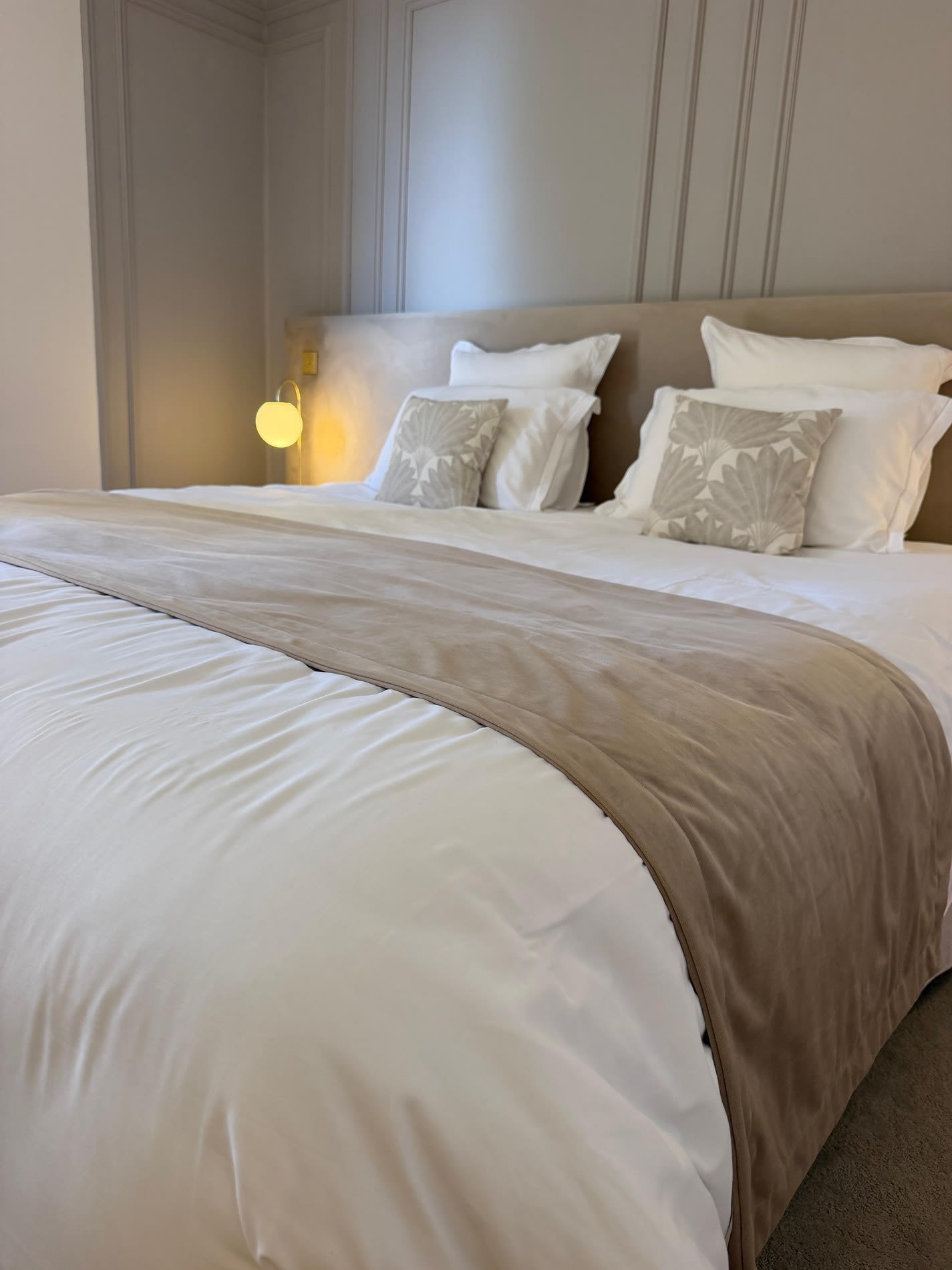 Le lit d'une chambre du Domaine de Rochebois, sous les boiseries
