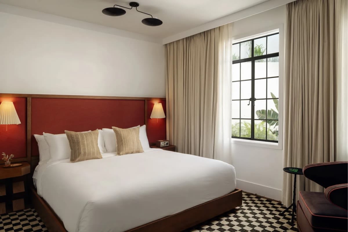 Chambre Signature King de l'hôtel Lucile, murs rouges et fenêtres à châssis d'acier