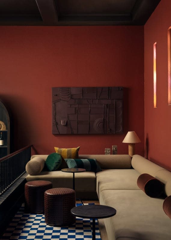 Salon d'un loft de l'hôtel Lucile, canapé et murs rouge brique
