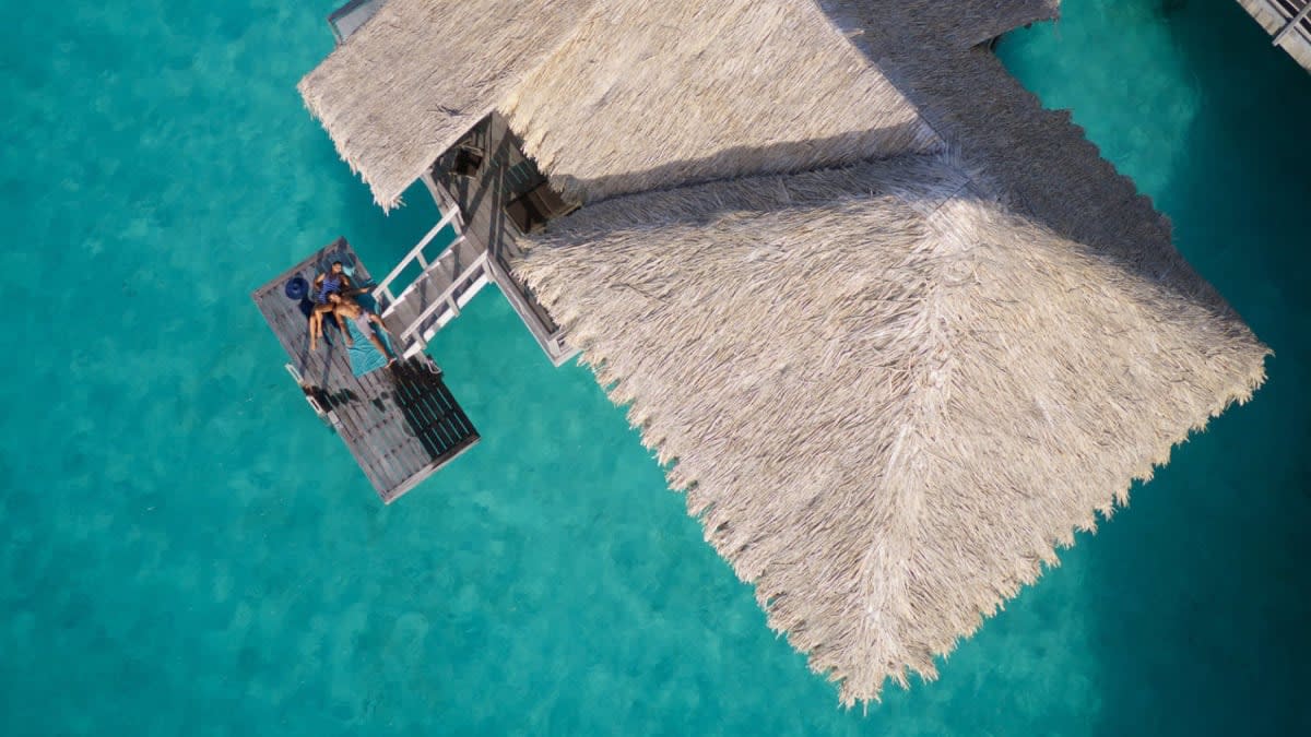 Villa sur pilotis de l'InterContinental Bora Bora vue du ciel, toit de pandanus et ponton sur le lagon