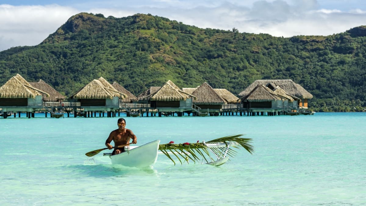 Pirogue polynésienne devant les villas sur pilotis de l'InterContinental Bora Bora
