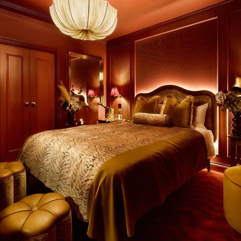 Cabin room at House of Gods Canary Wharf, gilded bed beneath a red velvet ceiling