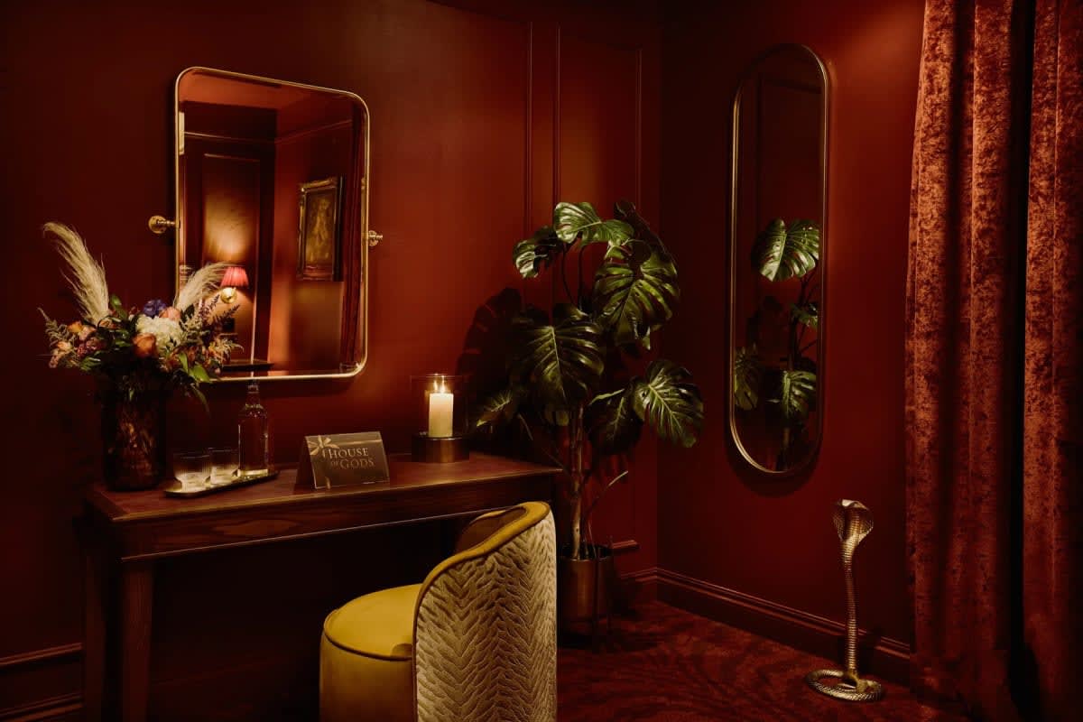 Dressing table and mirrors in a House of Gods Canary Wharf room, flowers and velvet