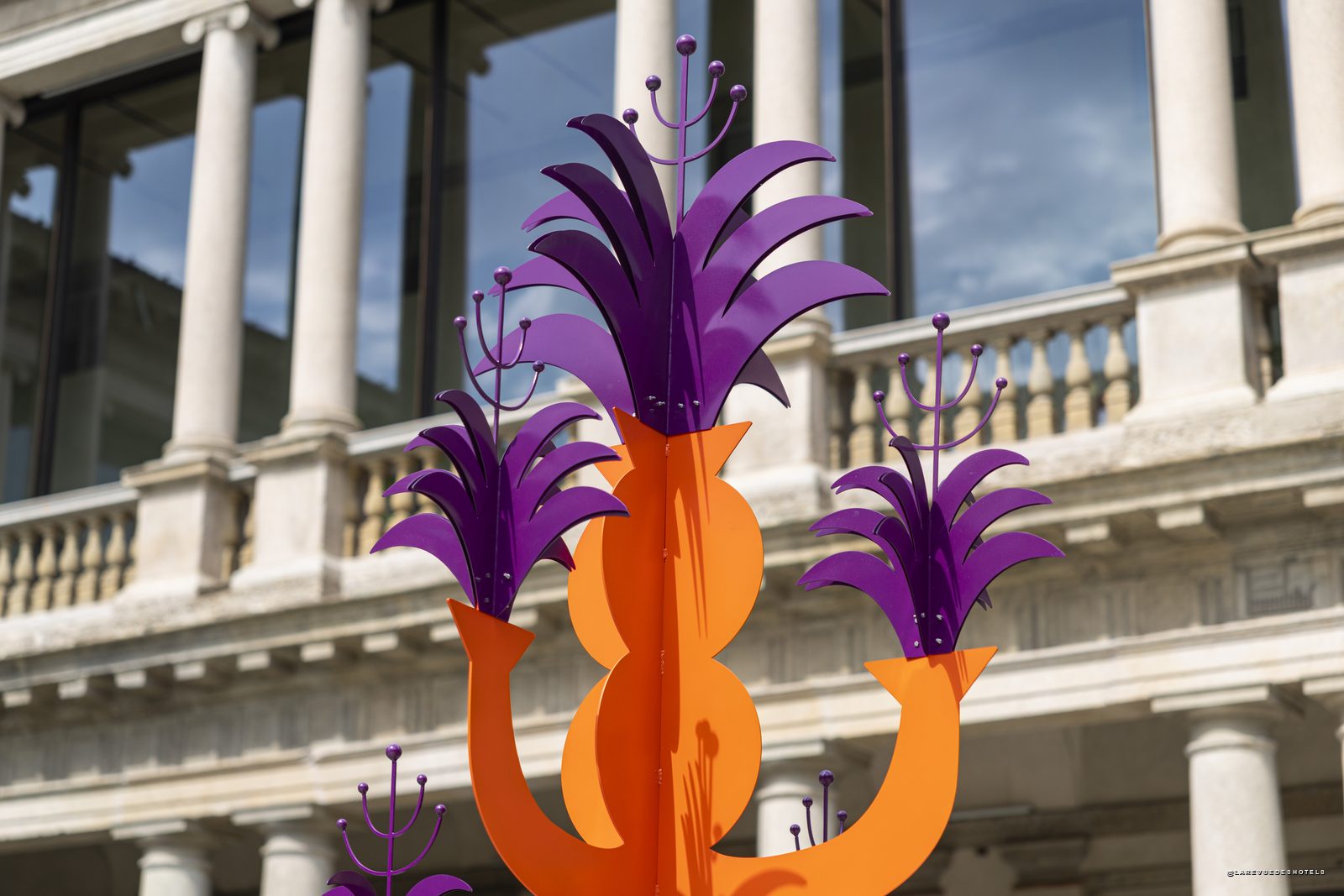Sculpture végétale orange et violette d'Agostino Iacurci devant la colonnade du Portrait Milano