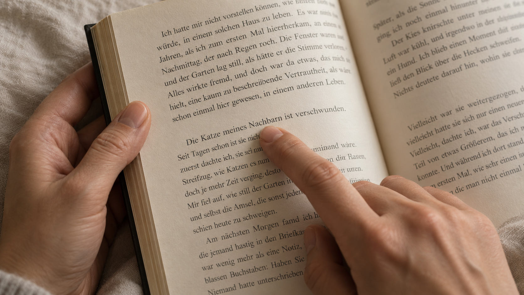 Reader's hands holding an open book, one finger resting gently under a single word on the page