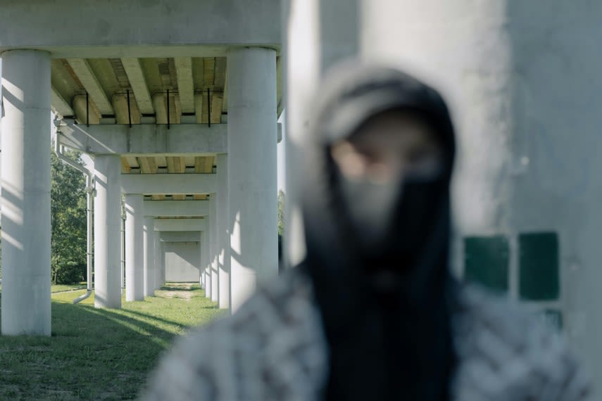 Polițist în uniformă cu cagulă și costum de camuflaj în acțiune Polițist în uniformă cu cagulă și costum de camuflaj în acțiune