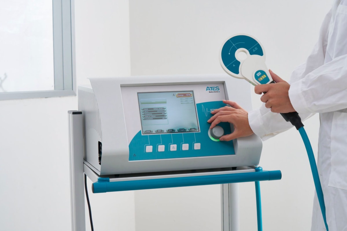 Doctor în halat alb utilizând aparat de stimulare magnetică la spital Doctor în halat alb utilizând aparat de stimulare magnetică la spital