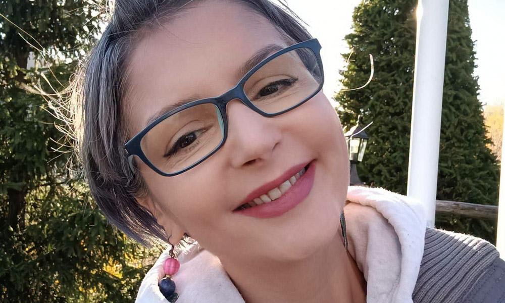 Carmen Coman în timpul unei activități caritabile, zâmbind