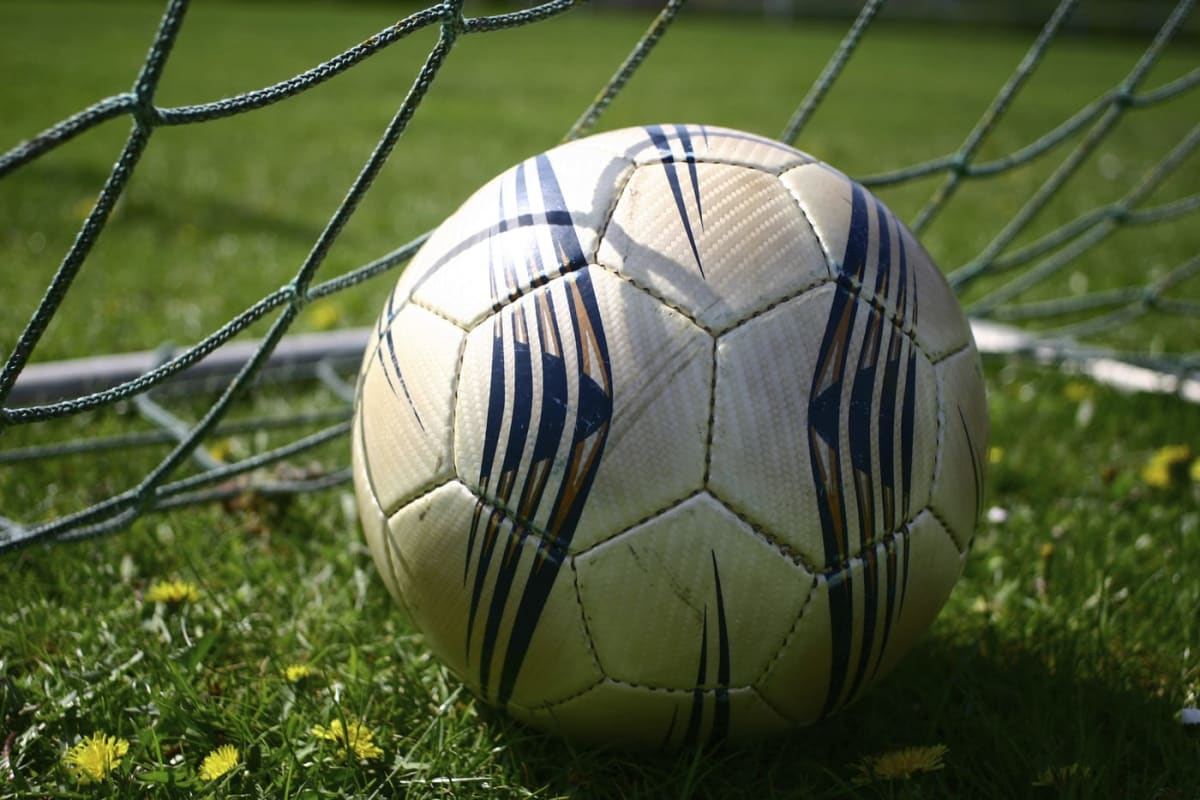 fotbalist portughez în tricou alb și roșu, pe teren