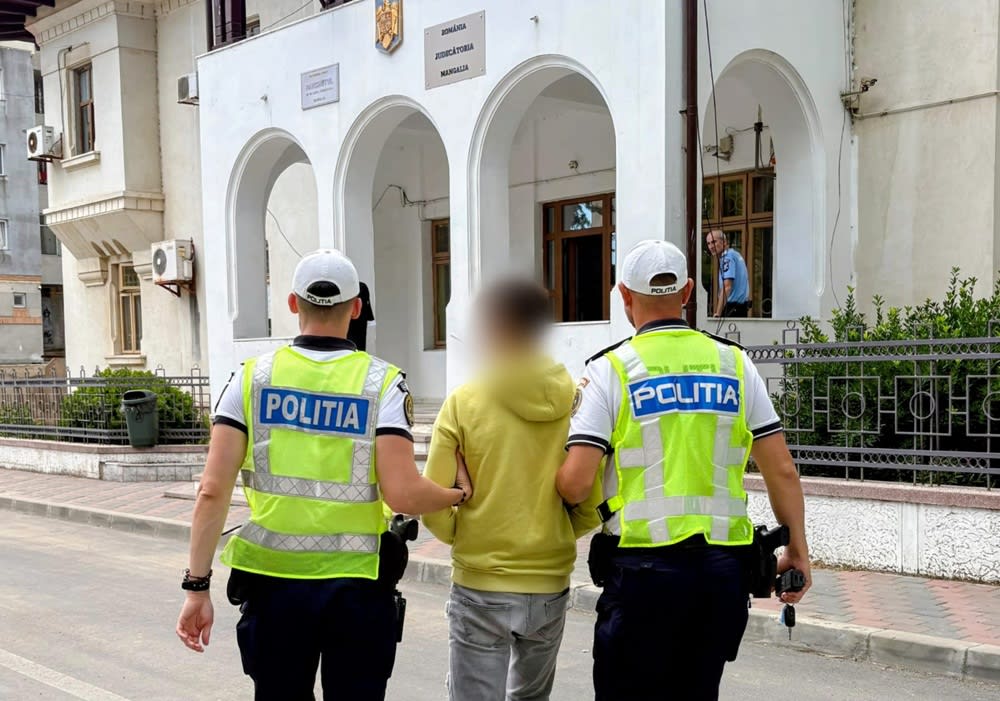 bărbat suspect în fața poliției, însoțit de polițiști