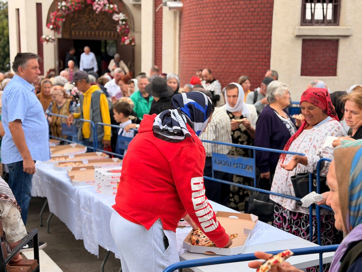 preot și enoriași la eveniment cu pizza