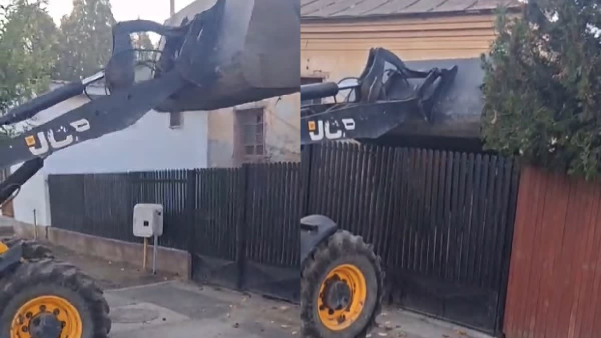 buldoexcavator răsturnând deșeuri peste poarta unei case