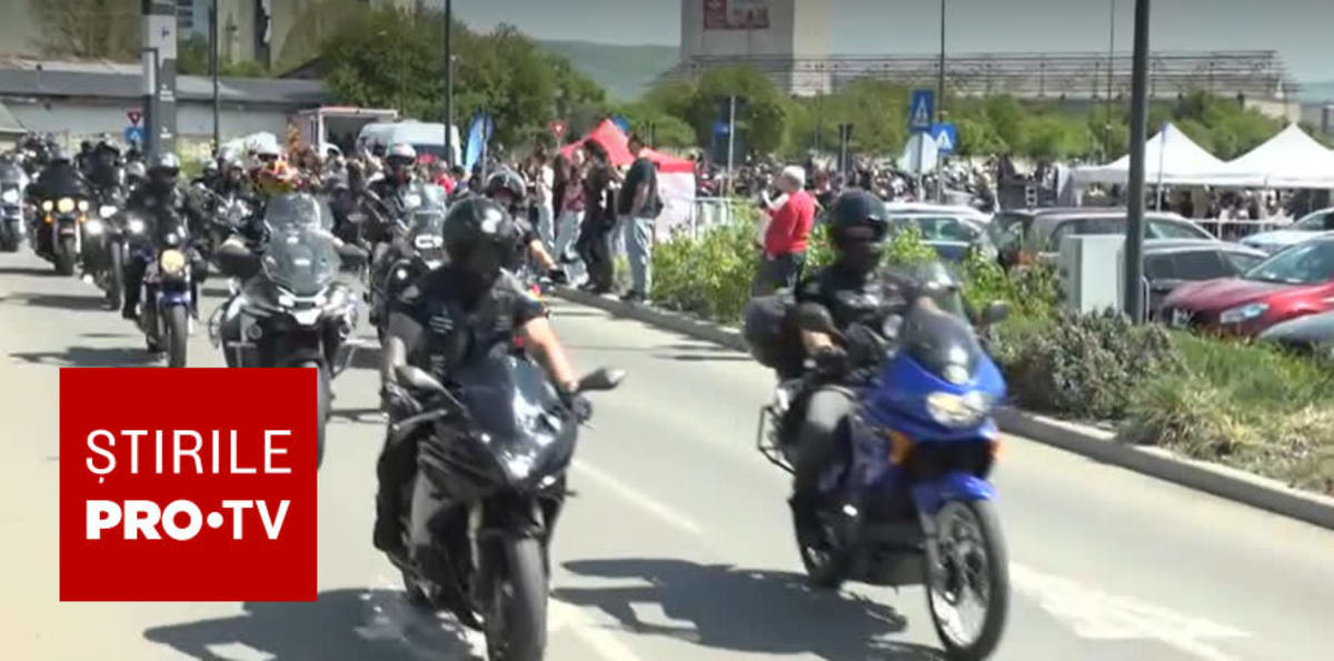 Motocicliști defilând în Alba Iulia, stradă plină de participanți și spectatori