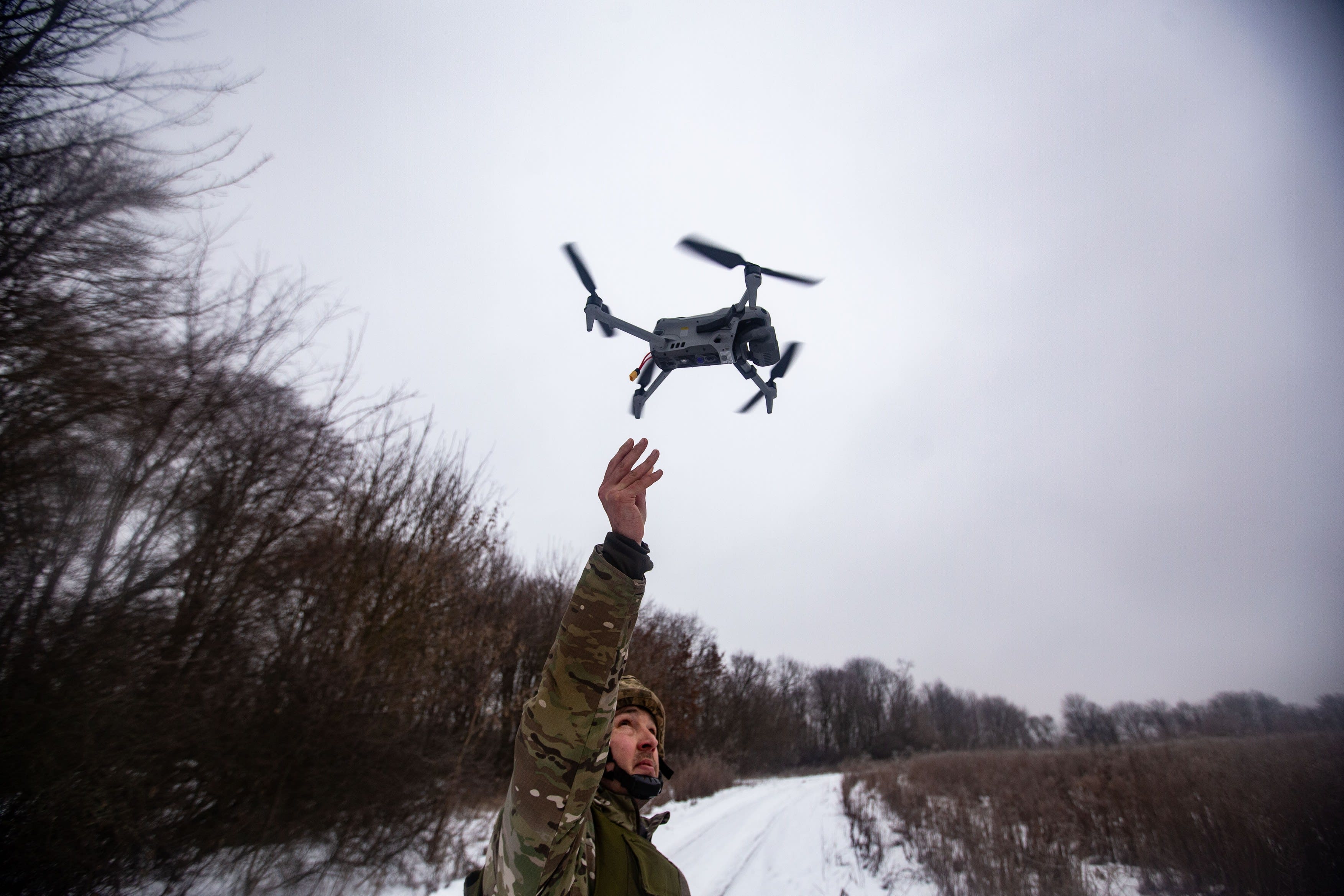 Soldat ucrainean lansând o dronă de supraveghere în timpul unui atac Soldat ucrainean lansând o dronă de supraveghere în timpul unui atac