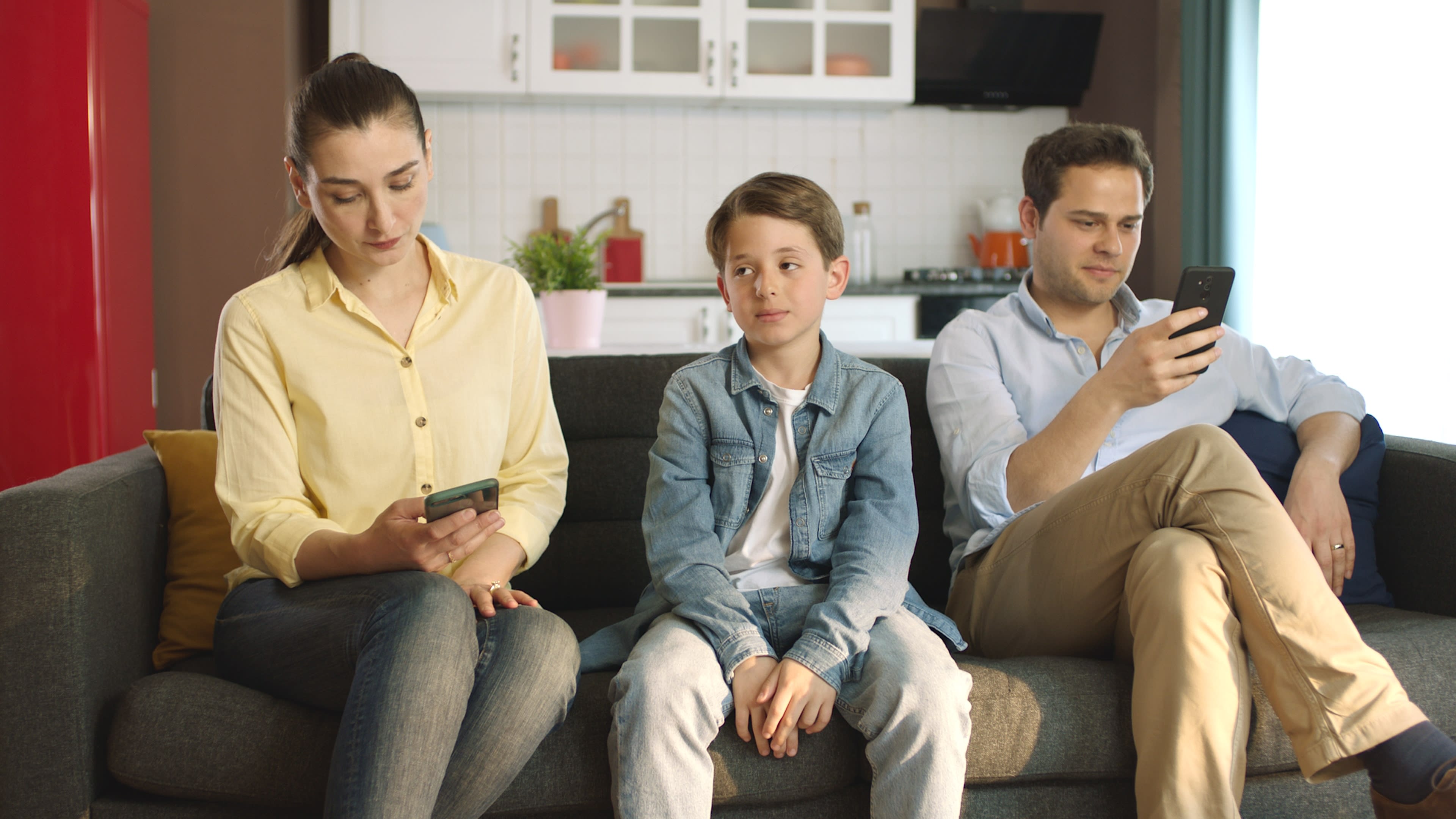 Copil între doi adulți care stau pe telefon, FOTO: Shutterstock Copil între doi adulți care stau pe telefon, FOTO: Shutterstock