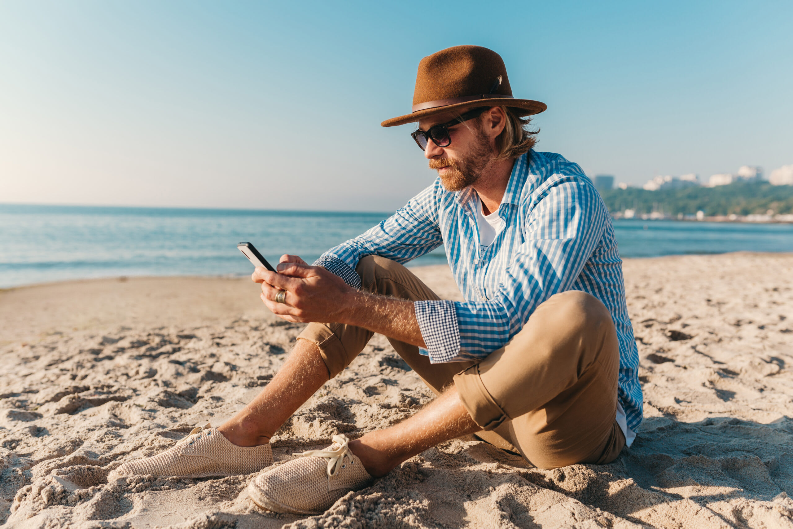 Persoană verificând e-mail pe telefon în vacanță, relaxare, activități outdoor Persoană verificând e-mail pe telefon în vacanță, relaxare, activități outdoor