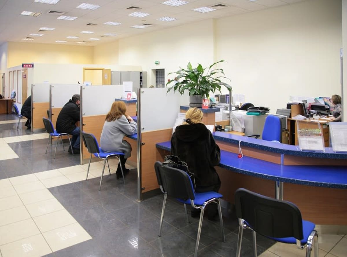 Clădire bancară modernă în România, cu logo bancar și oameni în față