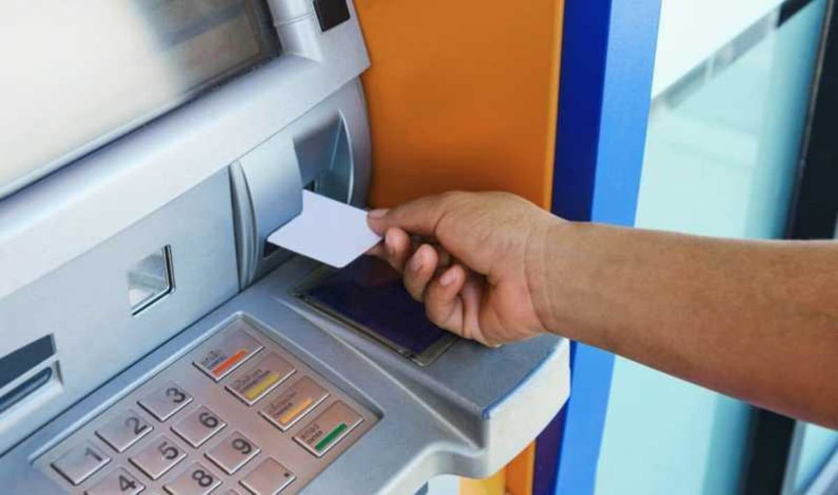 Persoană plătind cu cardul în străinătate, valute și carduri bancare