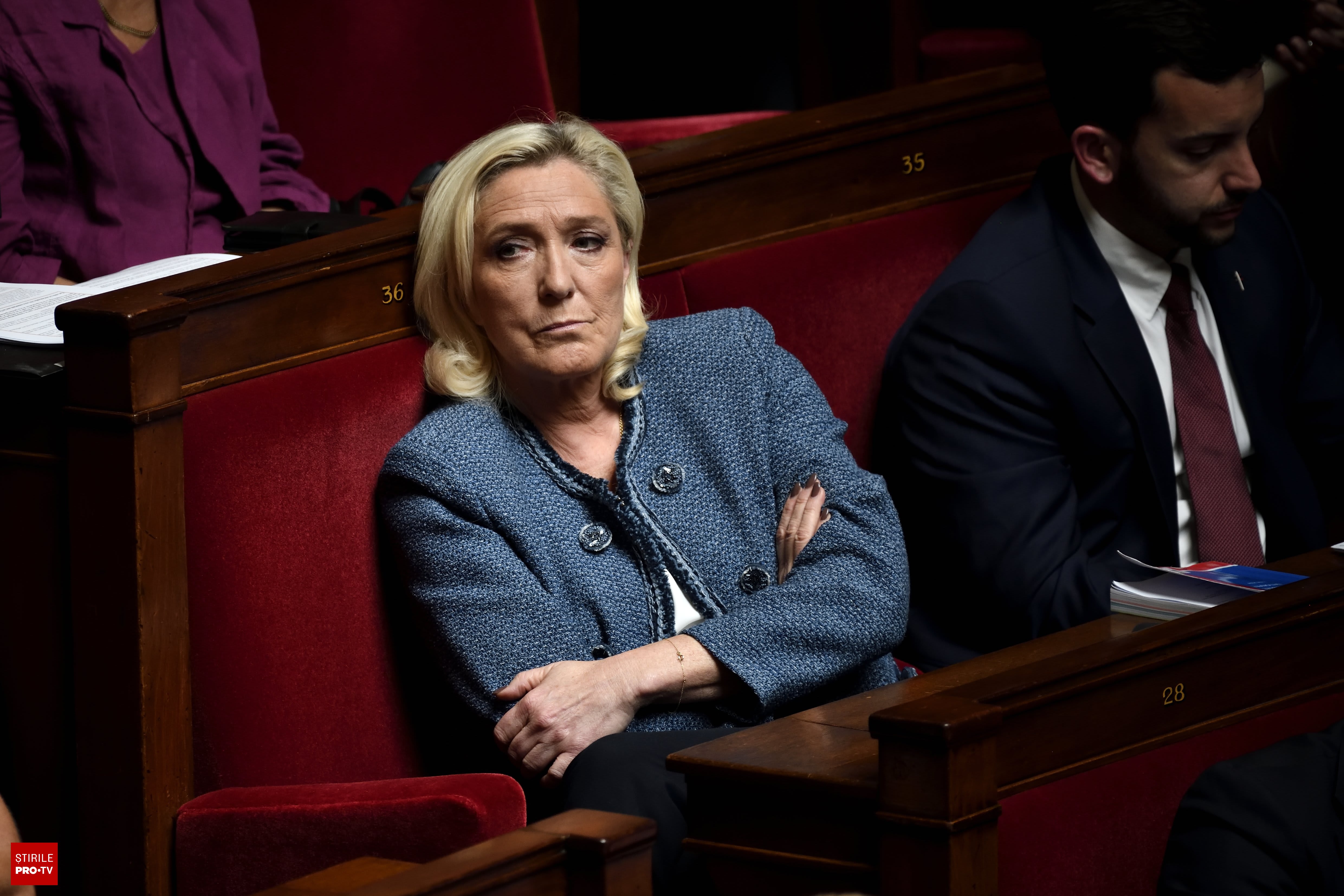 Marine Le Pen în fața tribunalului din Paris, cu documente și grefier