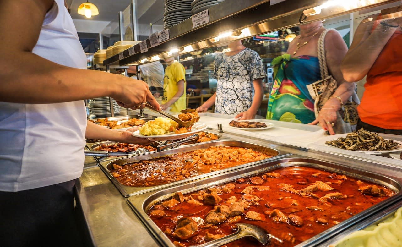 Turiști transportând alimente din bufetul hotelului în cameră