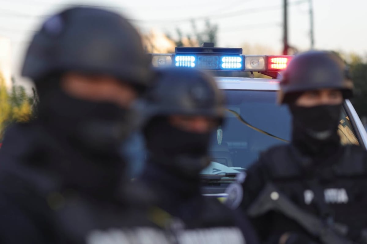 Polițiști mascați în fața unei autospeciale de intervenție