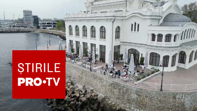 Terasa cafenelei de la Cazinou cu priveliște spre mare și turiști relaxați Terasa cafenelei de la Cazinou cu priveliște spre mare și turiști relaxați