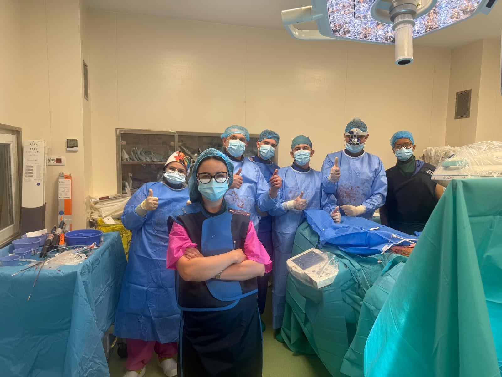 Echipă medicală realizând intervenție EVAR la pacient în sala de operații