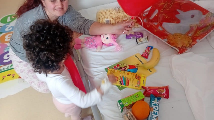 Copii internați în spital zâmbind și primind cadouri de Ziua Copilului