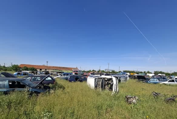 Primar Dominic Fritz în fața unui câmp cu mașini uzate