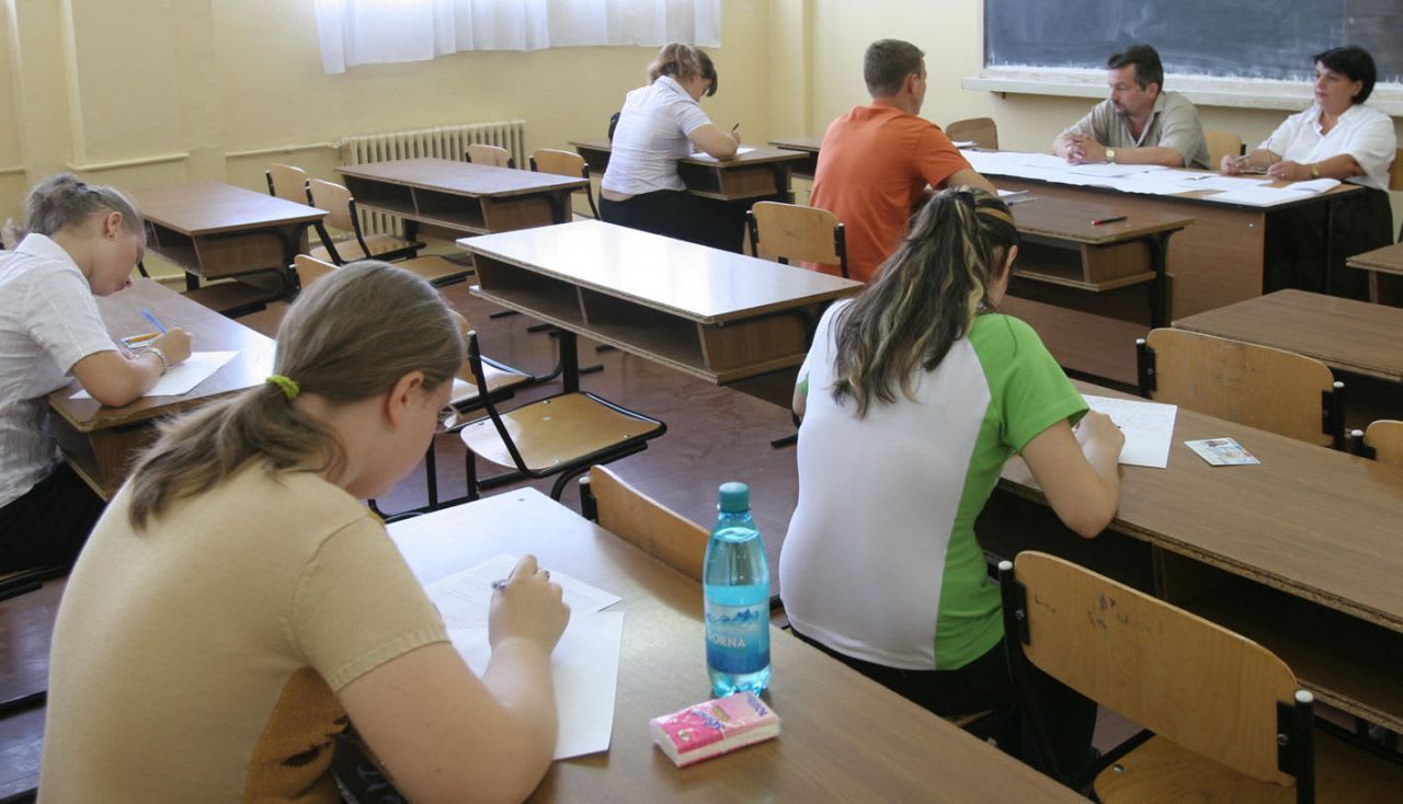 Elevi în clasă cu hărți digitale și telefoane inteligente învățând despre spațiul înconjurător