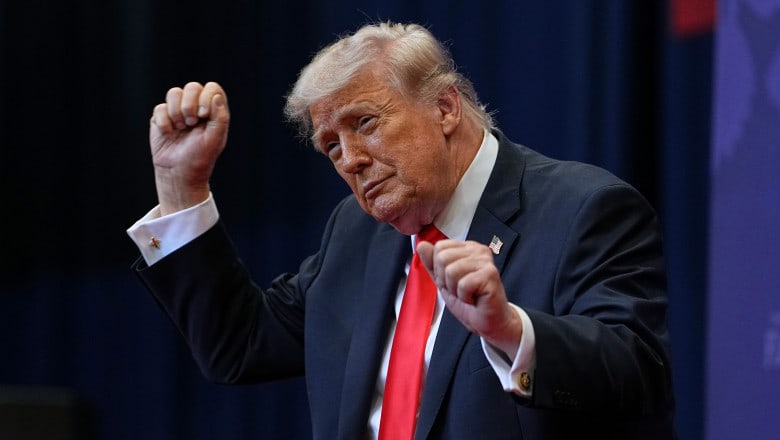 Donald Trump în fața unui ecran cu grafice financiare și criptomonede
