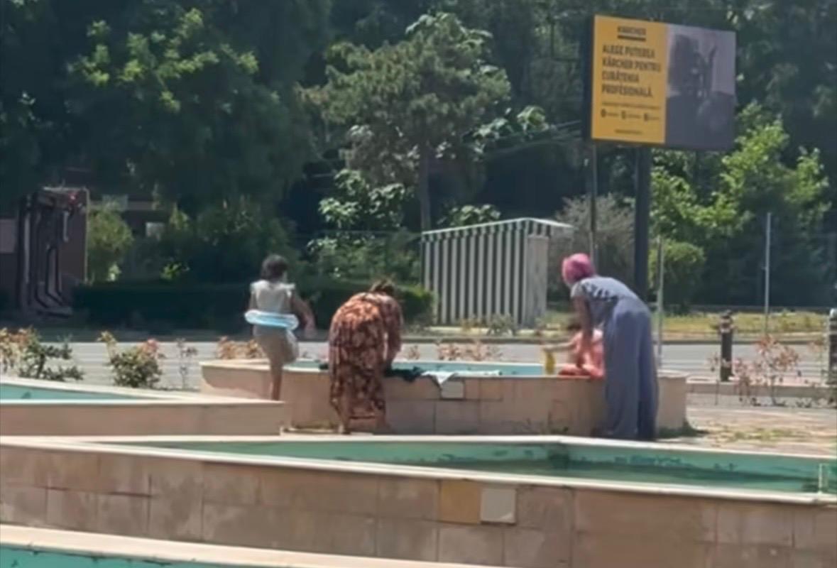 Oameni spălând haine și bălăcindu-se în fântânile arteziene din Constanța