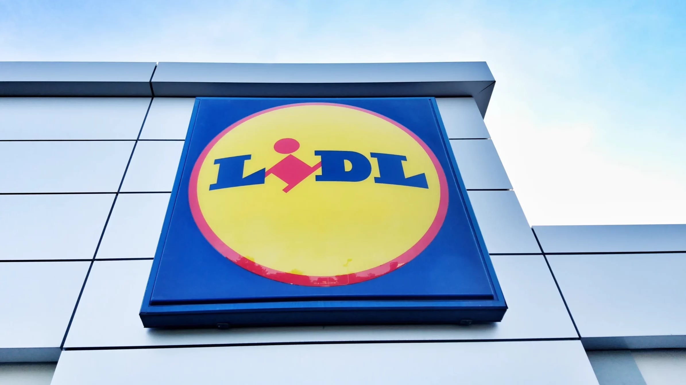 Client Lidl verificând bonul fiscal în magazin