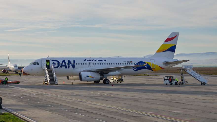 Echipaj de zbor în cockpit, aeronave în hangar, sezon estival