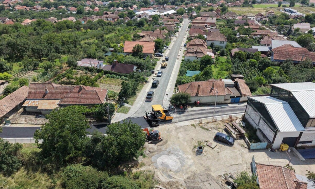 Lucrări de asfaltare pe străzile din Aiud, muncitori și utilaje