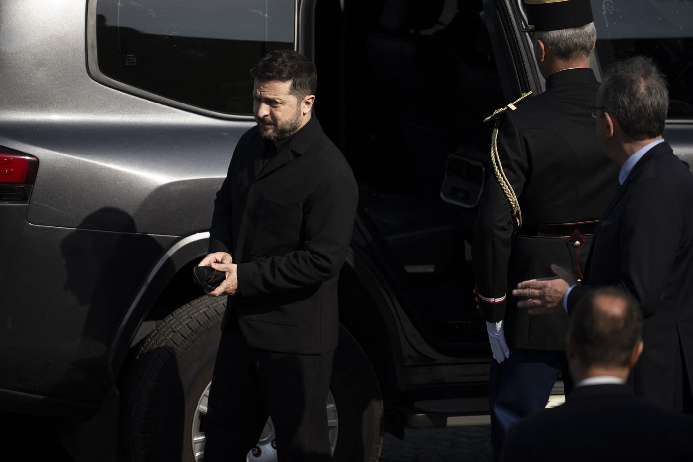 Președintele Zelenski în tribuna oficială la parada de Ziua Franței, în timp ce desface dopul unei sticle de plastic Președintele Zelenski în tribuna oficială la parada de Ziua Franței, în timp ce desface dopul unei sticle de plastic