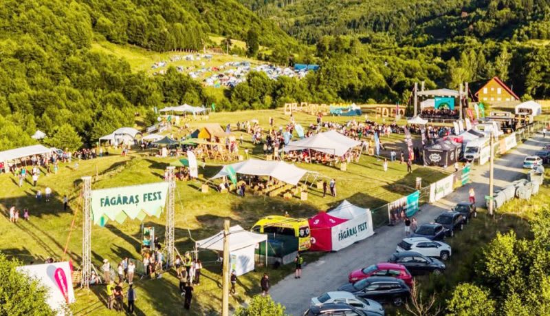 Participanți la festival în natură, cu munți și cascade în fundal Participanți la festival în natură, cu munți și cascade în fundal