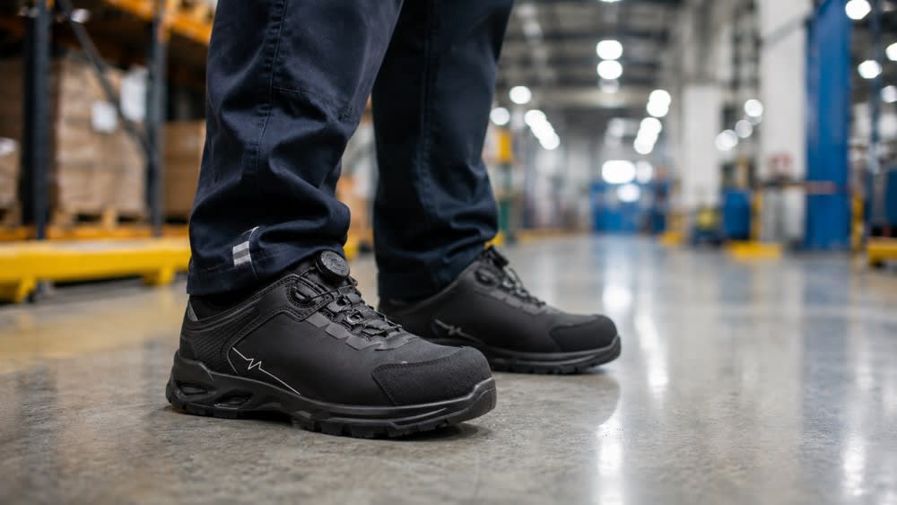 Specialist în încălțăminte de protecție verificând suportul ergonomic al unei perechi de încălțăminte