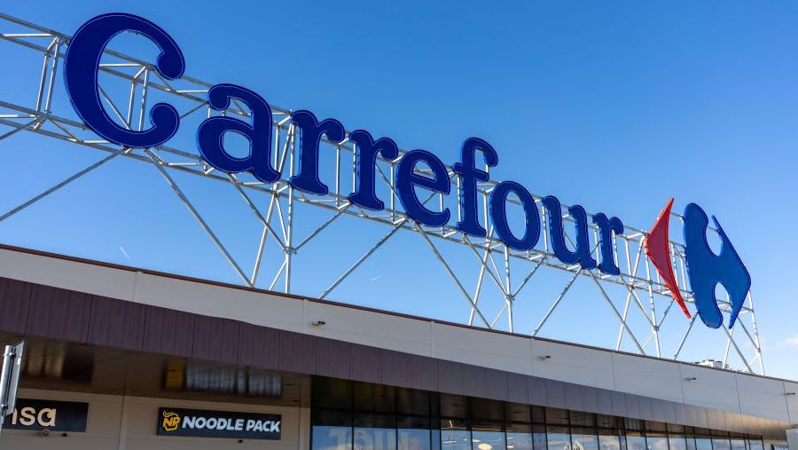 Angajat Carrefour asistând un client cu dizabilități în magazin